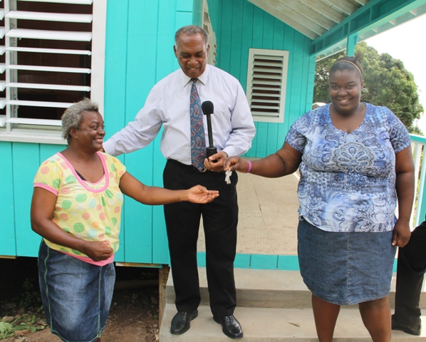 Premier of Nevis Hon. Vance Amory with Stoney Hill residents Vanessa Smithen (right) and her mother Pearl Smithen (left) moments after handing them the keys to a brand new home at Gingerland on June 24, 2016